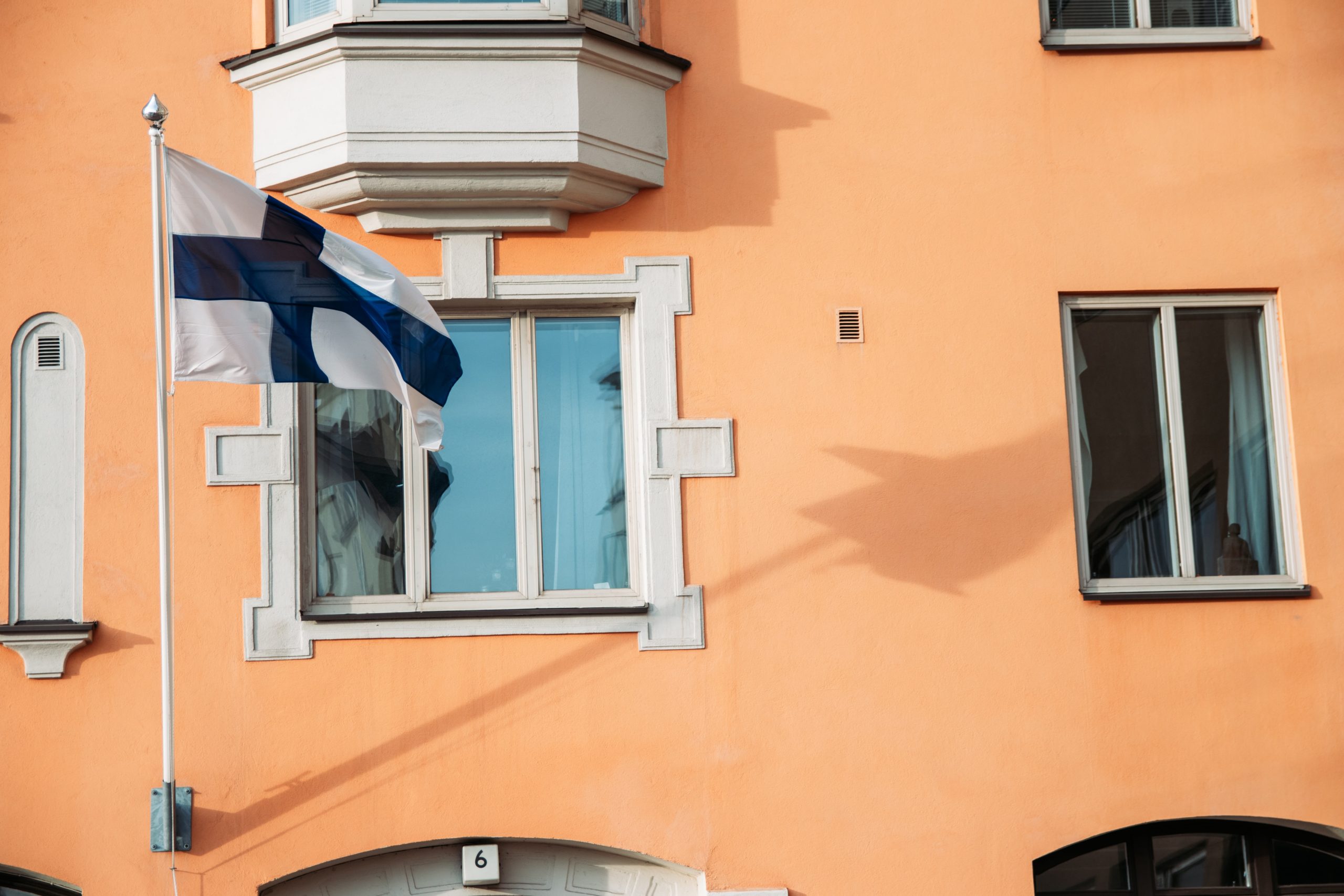 Finnish flag in front of an orange building